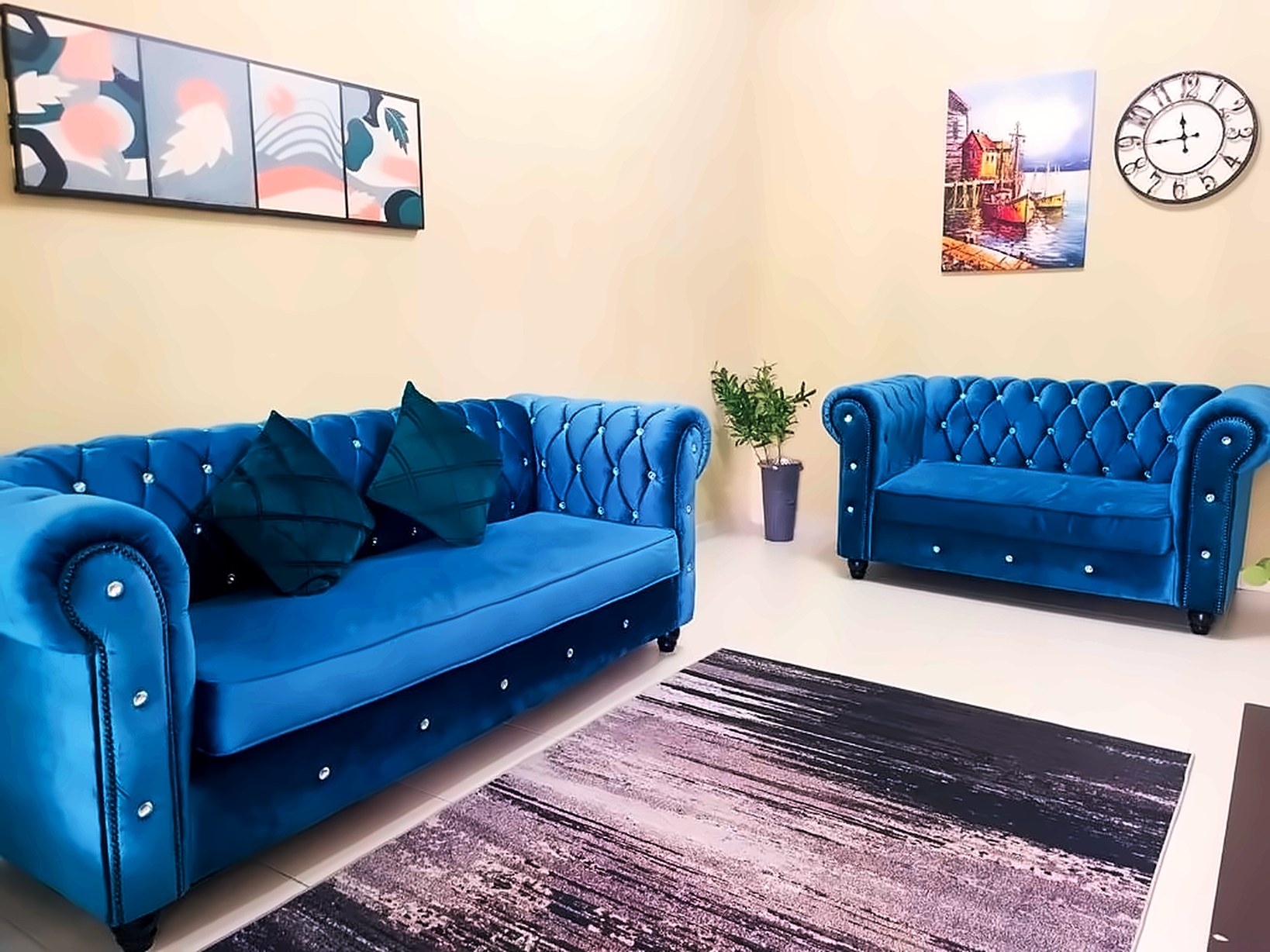 Sulong Inn Kuantan homestay living room with two blue velvet chesterfield sofas and artwork