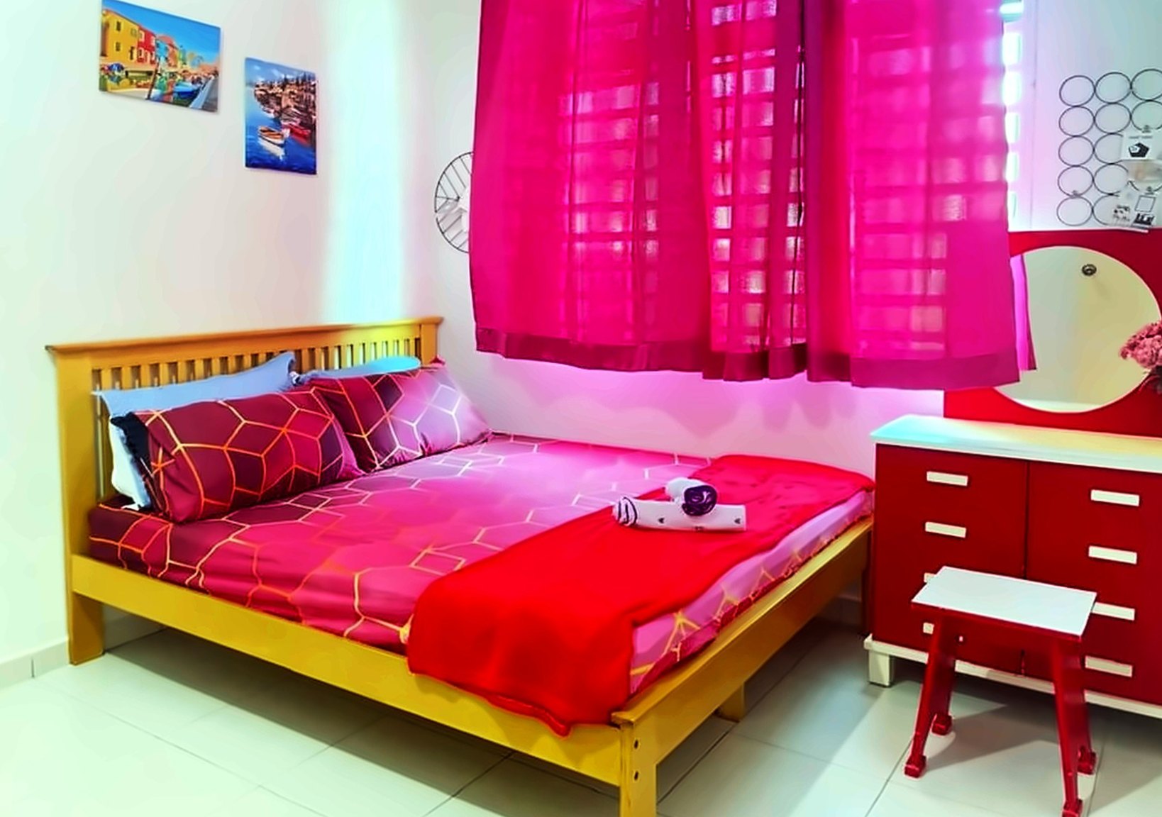 Bedroom with a wooden queen bed, pink curtains and a red dressing table